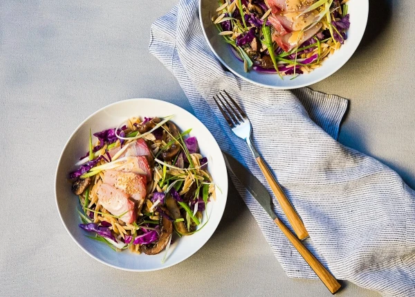 This photo was photographed under natural light at my home studio.  I love creating food that brings out the best from different cultures, in this case when East meets West.  Pan sautéed red cabbage, shallots and mushrooms mixed with orzo pasta, tossed with a miso ginger dressing; topped with hamachi(yellowtail) sashimi, sesame seeds and slivers of green onions.  I call this the “ Fusion Sushi Bowl”.  The textures, shapes and colors of the ingredients are the focal feature of this photo.