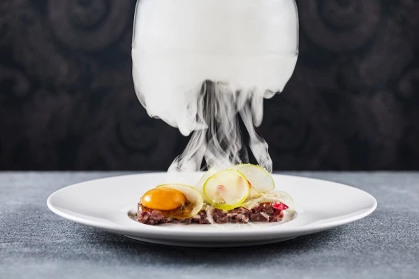 This dish was shot in M Restaurants (http://mrestaurants.co.uk) where the smoke fills the cloche as the plate is taken to the table, then removed releasing beautiful smoked apple and wagyu tartare.  The very talented Chef Mike Reid and entrepreneur owner Martin Williams head up the team at M in London. I love the texture of this dish - the delicacy of the apple and the light shining through it, added to that the dramatic jelly fish/cloud effect of the cloche being removed! More images can be seen at www.jodihinds.com or @jodihindsphoto.